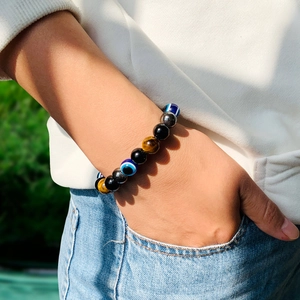 Gros plan d'un bracelet en perles Œil de tigre et Œil protecteur porté sur le poignet