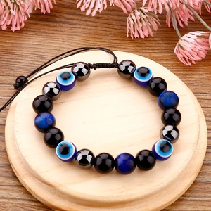 Détail d'un bracelet de perles œil maléfique avec pierres œil de tigre et cordon noir