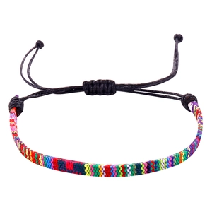 Detailopname van kleurrijke Boheemse geweven armband met verstelbare zwarte waskoordknoop
