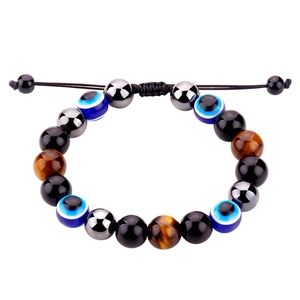 Détail des perles oeil de tigre et mauvais oeil sur bracelet tressé réglable