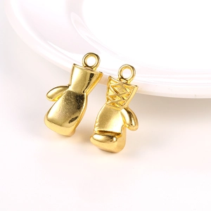 Detail of golden boxing glove charms with intricate lace-up texture and polished finish