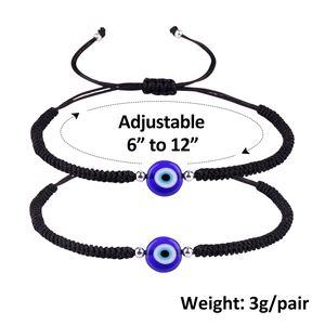 Detail of two adjustable black woven bracelets with blue evil eye beads and silver accents