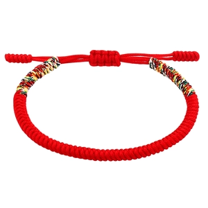 Detailed macro view of handmade red braided cord bracelet with colorful knotted accents
