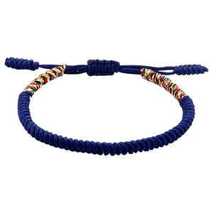 Macro shot of handcrafted Tibetan knot bracelet with blue cord and colorful silk thread details