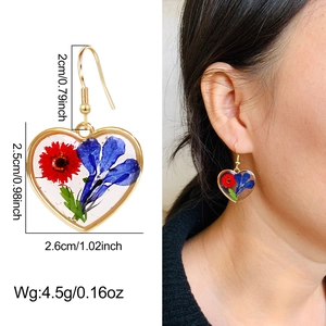 Detailed view of heart resin earrings with dried flowers and precise size measurements