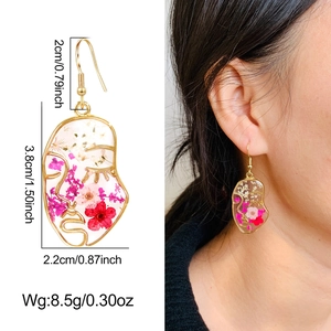 Detailed view of handmade flower resin earrings with dimensions and model display