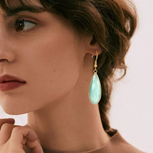 Détail de boucles d'oreilles pendantes vintage avec pierre vert menthe sur mannequin