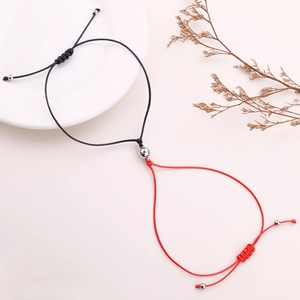 Detail of red and black magnetic heart coupling bracelets with adjustable braided ropes
