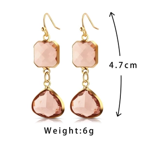 Vue détaillée des boucles d'oreilles pendantes en pierres roses facettées dorées