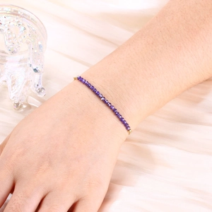 Detail of 3mm purple faceted natural stone beads on a gold-plated bracelet