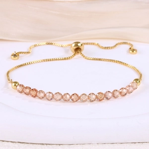 Detail of adjustable gold-plated bracelet with faceted champagne crystal beads and bolo clasp