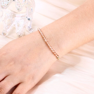 Detail of champagne crystal beaded bracelet with faceted beads on a silk background