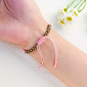 Detail eines handgefertigten gewebten Paar-Armbands in kräftigen Farben am Handgelenk