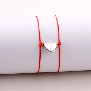 Close-up of red braided rope bracelet featuring a polished silver heart magnetic clasp