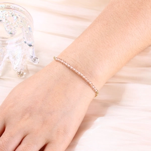 Close-up of a 3mm pink crystal beaded bracelet on wrist with gold bead accents