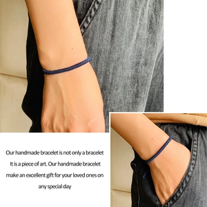Detail eines dunkelblauen handgewebten Armbands mit feiner Textur am Handgelenk