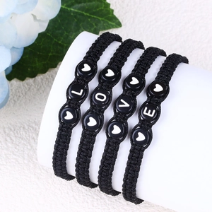Detail of four black braided bracelets with LOVE lettering and heart shaped beads