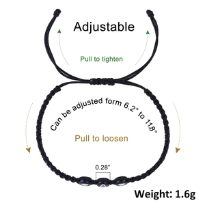Detail of adjustable black woven bracelet showing heart beads and letter A charm