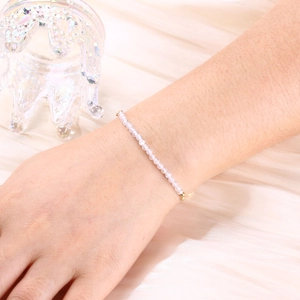 Detail of 3mm natural pink crystal beaded bracelet with gold plated accents on wrist