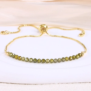 Detail of 3mm olive green faceted crystal beads on an adjustable gold box chain bracelet