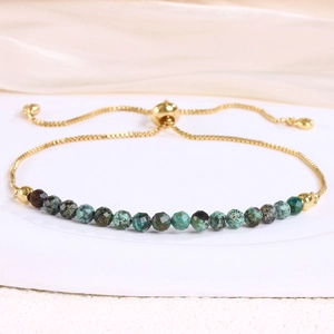 Detail of adjustable gold snake chain bracelet with 4mm faceted turquoise beads