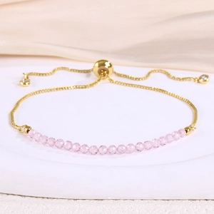 Detail of pink crystal beads and adjustable gold chain bracelet on elegant marble base