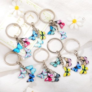 Detailed view of colorful enamel butterfly pendants and keychains set on white background