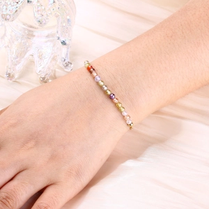 Detail of colorful faceted crystal beads on a gold snake chain worn on a wrist