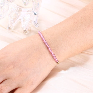 Detailed macro view of delicate 4mm faceted pink crystal beads and gold-plated chain