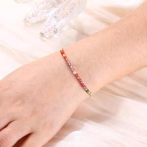 Detailed shot of a 3mm multi-color gemstone beaded bracelet with gold plated clasp on wrist