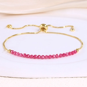Detail of adjustable gold bracelet with pink faceted crystal beads and sliding clasp