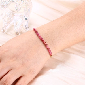 Detail of pink crystal beaded bracelet with gold accents on elegant satin fabric