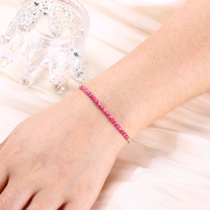 Detailed close-up of pink crystal beaded bracelet on wrist with gold-plated metal accents