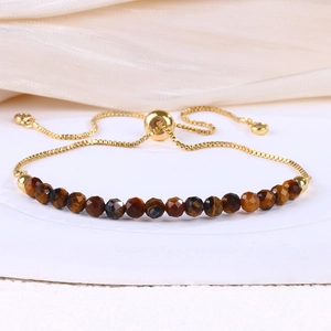 Detail of adjustable gold box chain with multifaceted tiger eye beads and slider clasp