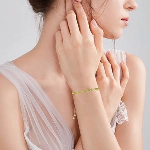 Detail of adjustable gold-plated chain bracelet featuring faceted green crystal beads