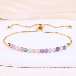 Detail of adjustable gold slider bracelet with faceted colorful crystal beads and chain