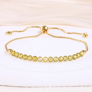 Macro shot of 4mm yellow crystal beads on a gold snake chain with adjustable slider clasp