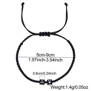 Pulsera trenzada negra ajustable con letra A y cuentas de corazón sobre fondo blanco