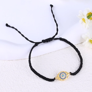 Detailed view of handmade woven black cord bracelet with gold zircon Evil Eye charm