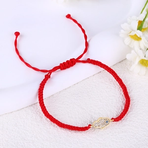Detail of red braided Hamsa hand bracelet with zircon pavé and blue evil eye charm