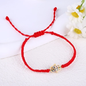 Detail of red woven Hamsa Hand bracelet with colorful zircons and evil eye charm