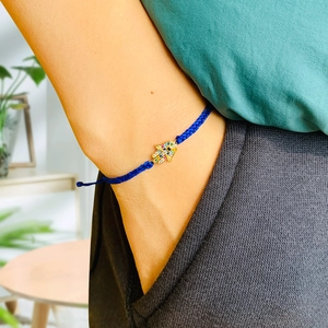 Detailed close-up of blue braided Hamsa Hand bracelet with inlaid colorful zircon stones