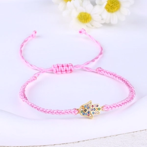 Detailed macro of pink Hamsa Hand bracelet with colorful zircons and Evil Eye charms