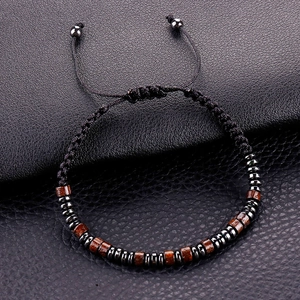 Macro shot of obsidian and wooden beads on a woven adjustable cord bracelet for men