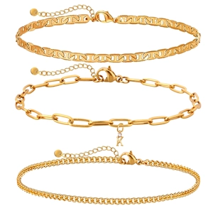 Détail d'un ensemble de trois bracelets dorés avec pendentif lettre K en zircon