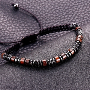 Detail of adjustable Morse code beaded bracelet with dark wood and metallic accents