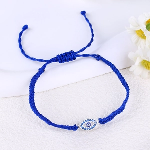 Detailed view of handmade blue woven bracelet featuring an evil eye charm with blue crystals