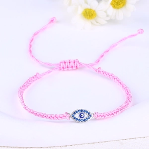 Macro shot of pink braided Evil Eye bracelet with blue zircon and adjustable drawstrings