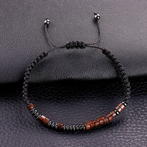 Detail of hand-woven bracelet with wooden beads and adjustable slider on leather