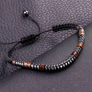 Morse code braided bracelet with obsidian and wood beads on black leather background